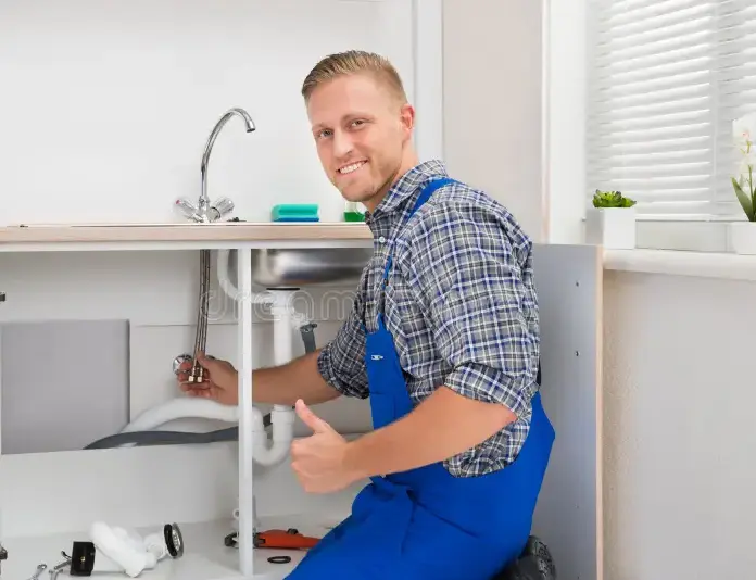 plumber-repairing-faucet-kitchen-happy-male-sink-57701595